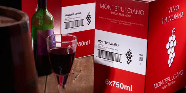 Red wine glass and bottle next to a box with Domino label