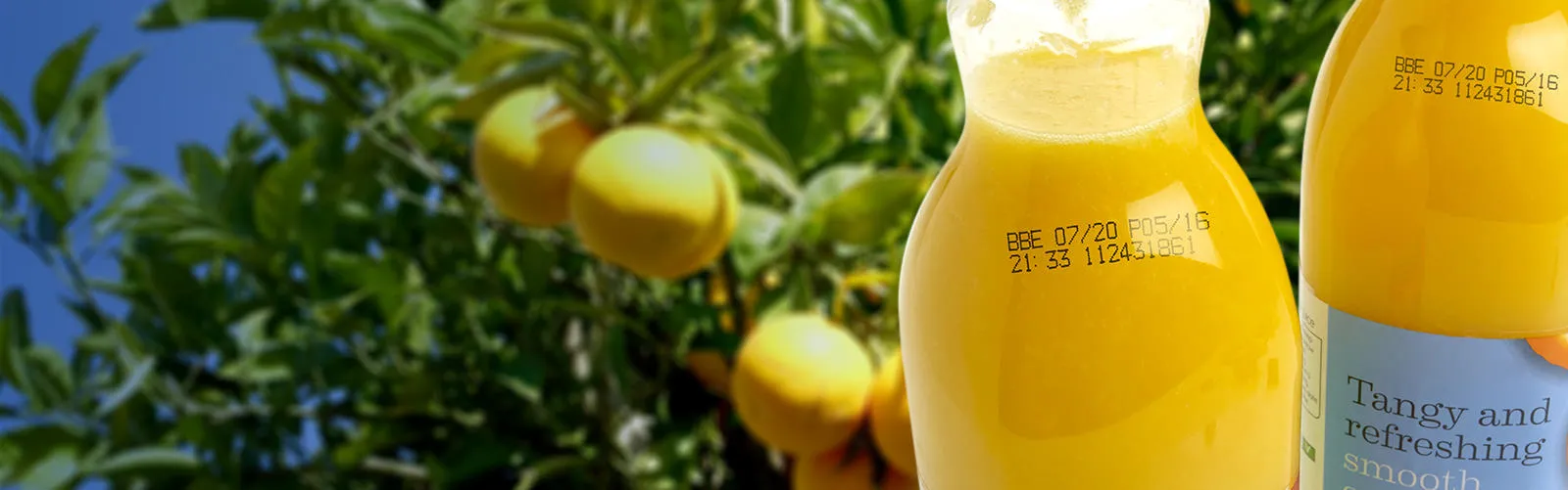 Black continuous inkjet printer code on plastic orange juice bottles, including best before date