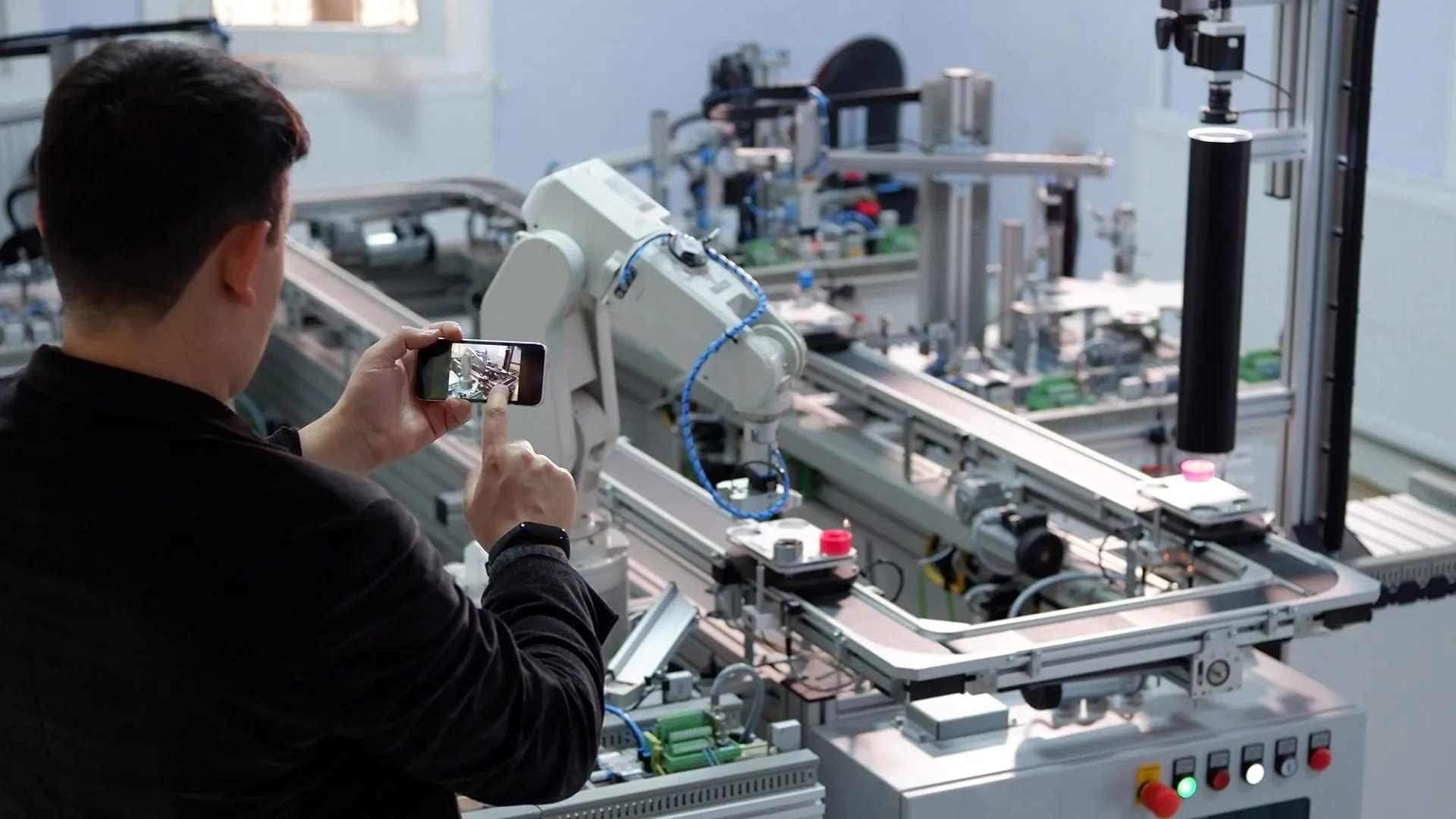 A man using Domino AR app on his phone to help detect issues on a production line