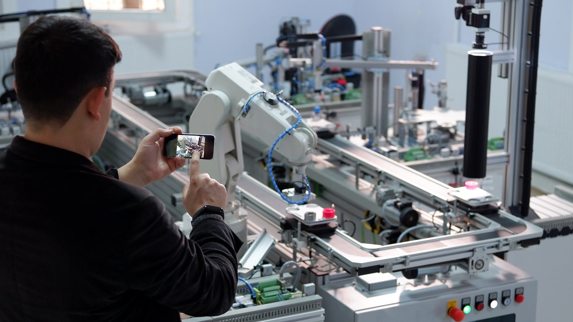 A man using Domino AR app on his phone to help detect issues on a production line
