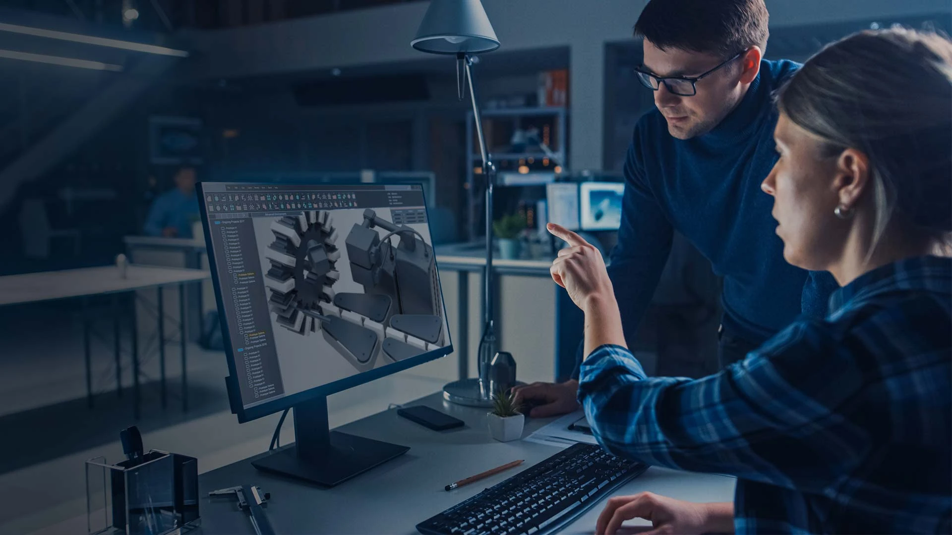 A woman showing a man a production line on a computer screen